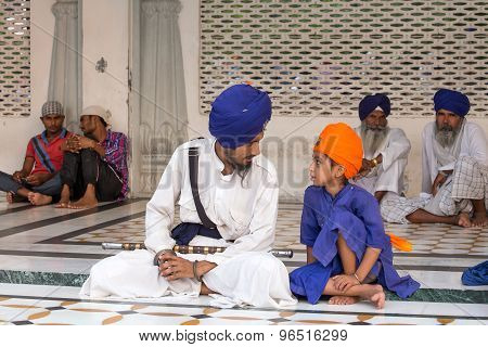 Sikh Man And Boy Visiting The Golden Temple In Amritsar, Punjab, India.