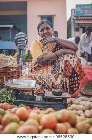 KAMALAPURAM, INDIA - 02 FABRUARY 2015: Indian lady sells vegetables on a market close to Hampi. Post-processed with grain, texture and colour effect.