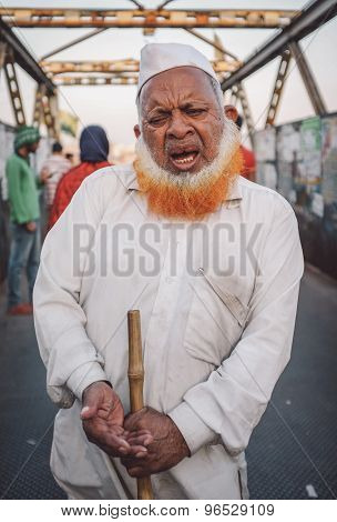 MUMBAI, INDIA - 12 JANUARY 2015: Indian blindman begs on bridge in Dharavi slum. Post-processed with grain, texture and colour effect.