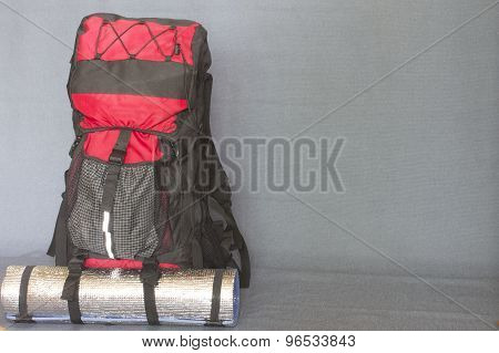 backpack tourists gathered to march black backpack with red and blue mat gray background