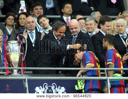 LONDON, ENGLAND. May 28 2011: Barcelona's forward Lionel Messi gets his winners medal from UEFA President Michel Platini after winning the 2011UEFA Champions League final