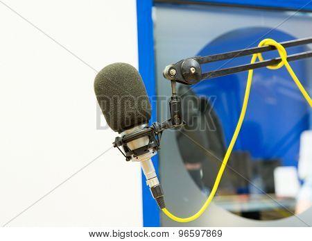technology, electronics and audio equipment concept - close up of microphone at recording studio or radio station