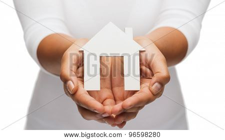 real estate concept - closeup of woman hands holding paper house
