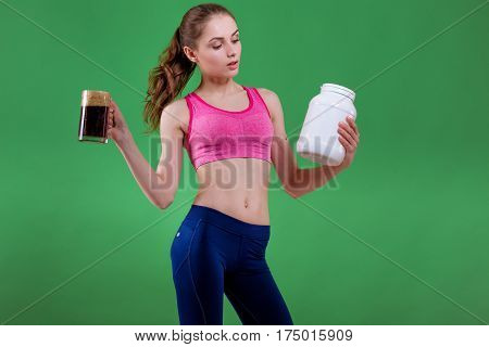 Caucasian girl that chooses to drink beer or eat of sports nutrition. Choice concept.