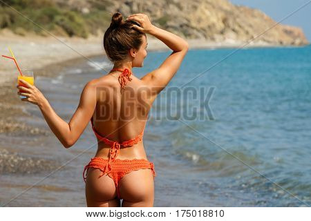 Beautiful woman on the beach with a glass of cocktail