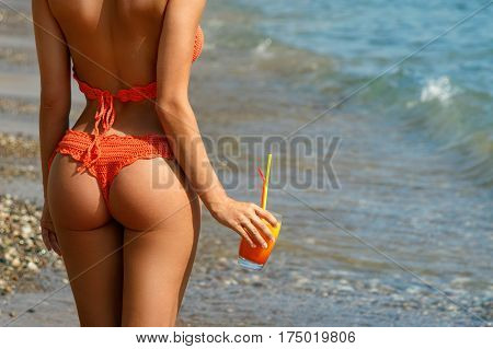 Beautiful woman on the beach with a glass of cocktail