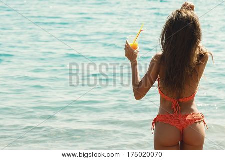Beautiful woman on the beach with a glass of cocktail