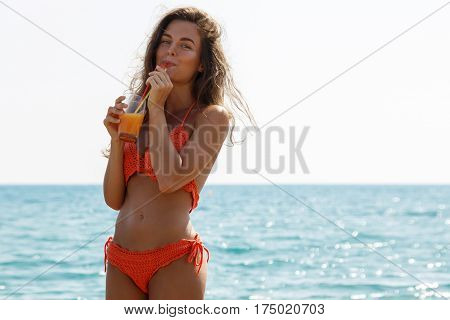 Beautiful woman on the beach with a glass of cocktail