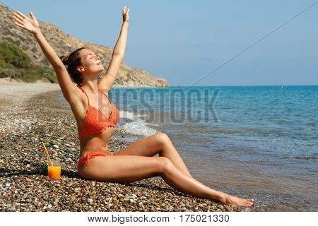 Beautiful woman on the beach with a glass of cocktail