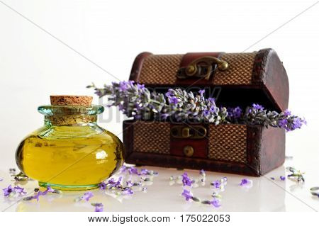 Lavender oil and lavender flower arrangement on light background