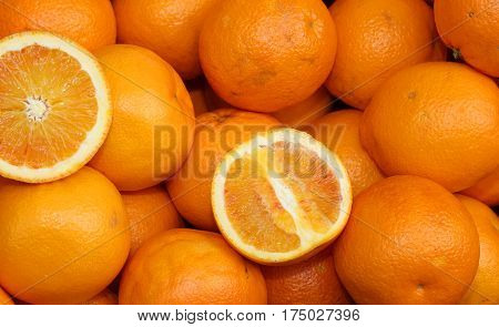 Ripe Oranges And An Orange Cut In The Stall Of Greengrocer
