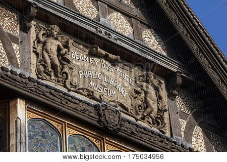 A close-up of the sculptured plaque on the facade of The Beaney House of Art and Knowledge in Canterbury England.