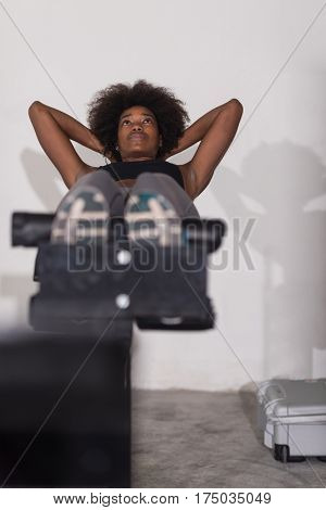 young fit african american woman doing sit ups in fitness studio at the gym.Abdominal exercises Sit up