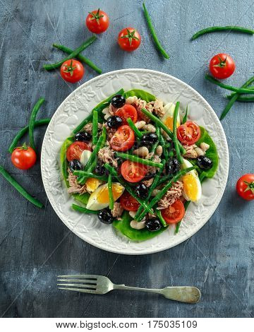Fresh Tuna Green Bean salad with eggs, tomatoes, beans, olives on white plate. concept healthy food.