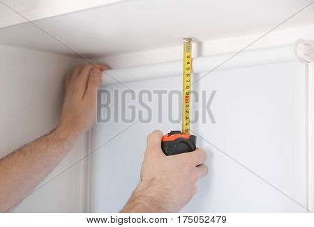 Male hands making window measurements