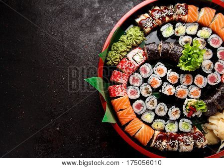Japanese Cuisine. Sushi Set In A Round Plate Over Dark Concrete Background.