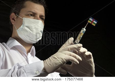 Young Man As A Doctor Gives A Medical Injection To Central African Republic Flag On A Black Backgrou