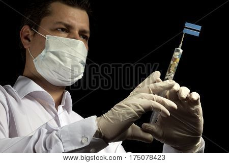 Young Man As A Doctor Gives A Medical Injection To Botswanan Flag On A Black Background