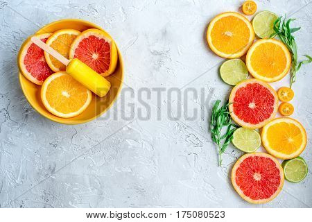 fresh citrus slices with fruit popsicles on stone table background top view mock up