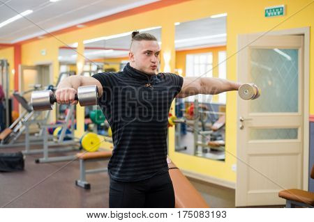 Young handsome athlete in old rusty gym.