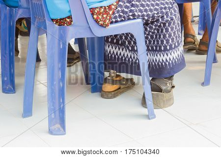 closeup asian old woman with aluminium prostheses on blue chair