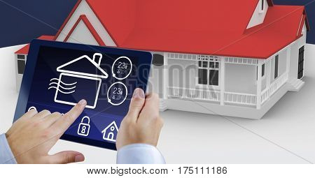 Digital composite image of hands using digital tablet with home security icons