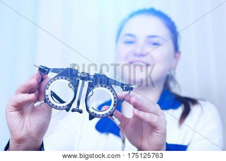 Close-up of optometrist holding messbrille glasses in ophthalmology clinic. Ophthalmic glasses for diopter detection.