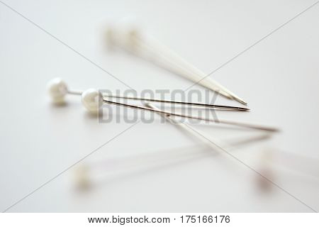 needlework and tailoring concept - sewing pins