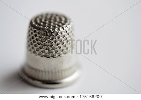 sewing, needlework and tailoring concept - close up of thimble