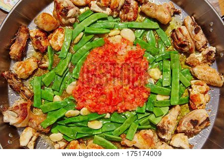 Paella from Spain recipe process ad vegetables green beans and tomato