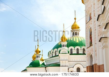gilded domes against the sky in Kiev Lavra monastery. in the foreground is seen the church wall with stucco Baroque