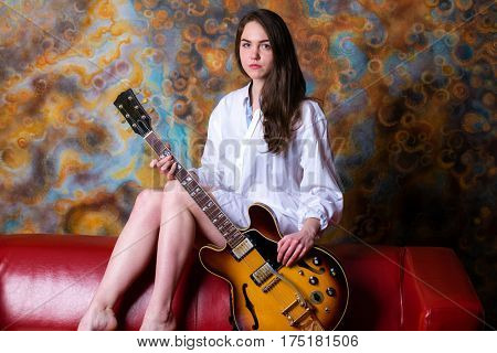 Podolsk, Russia - February 21, 2017: Young brunette girl with a vintage electric guitar Gibson es-345 1969 model year