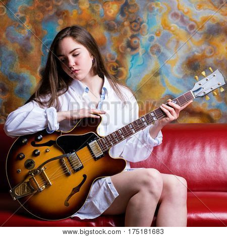 Podolsk, Russia - February 21, 2017: Young brunette girl with a vintage electric guitar Gibson es-345 1969 model year