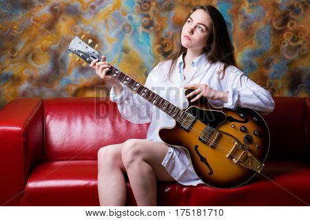 Podolsk, Russia - February 21, 2017: Young brunette girl with a vintage electric guitar Gibson es-345 1969 model year