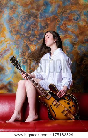 Podolsk, Russia - February 21, 2017: Young brunette girl with a vintage electric guitar Gibson es-345 1969 model year
