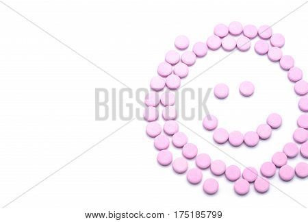 Smile face of pink pills on white background. Tablets of drug for asthma treatment.