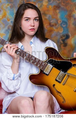 Podolsk, Russia - February 21, 2017: Young brunette girl with a vintage electric guitar Gibson es-345 1969 model year