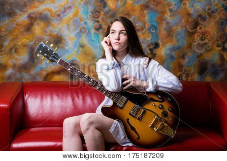 Podolsk, Russia - February 21, 2017: Young brunette girl with a vintage electric guitar Gibson es-345 1969 model year