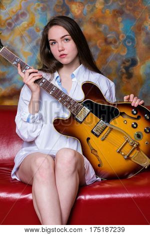 Podolsk, Russia - February 21, 2017: Young brunette girl with a vintage electric guitar Gibson es-345 1969 model year