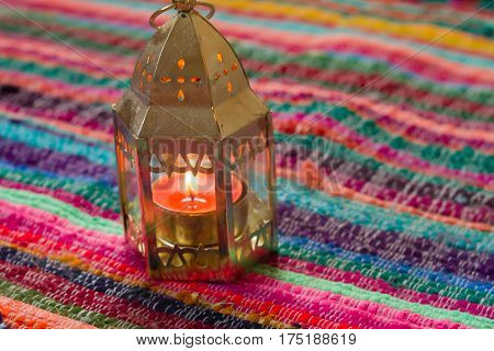 pink candle on a colorful handmade fabric .