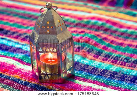 pink candle on a colorful handmade fabric .