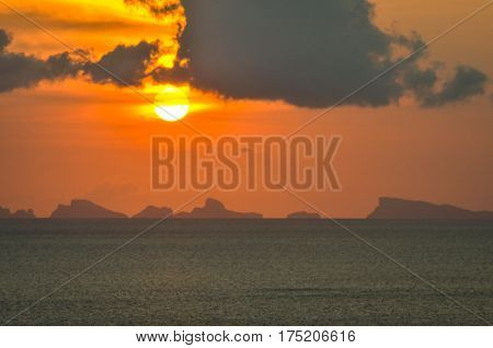 perfect sun hides behind clowds dramatic and colorful sunset at beach