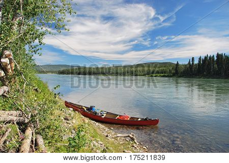 Red towed and abandoned canoe on Yukon River