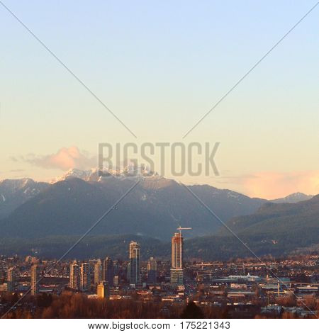 Cityscape And Mountains At Sunset