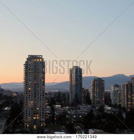 Cityscape And Mountains At Sunset