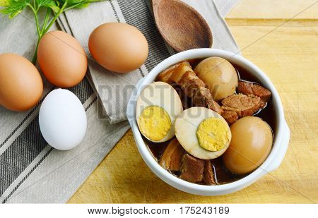 Eggs Stewed or Thai name is khai phalo muu saam chan on wooden background.