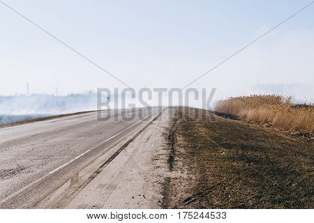 Burning steppe along the road. Burns dry grass.