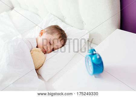 Little Boy Child Sleeping In Bed. Hugging His Favourite Teddy Bear