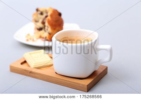 Classic espresso in white cup with cake and chocolate on white background