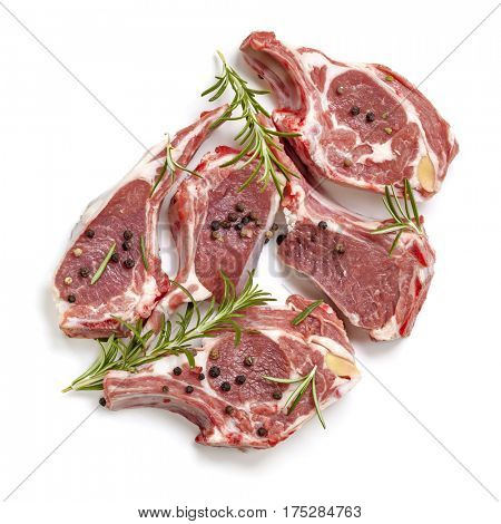 Raw lamb cutlets, top view, isolated, with rosemary and peppercorns.